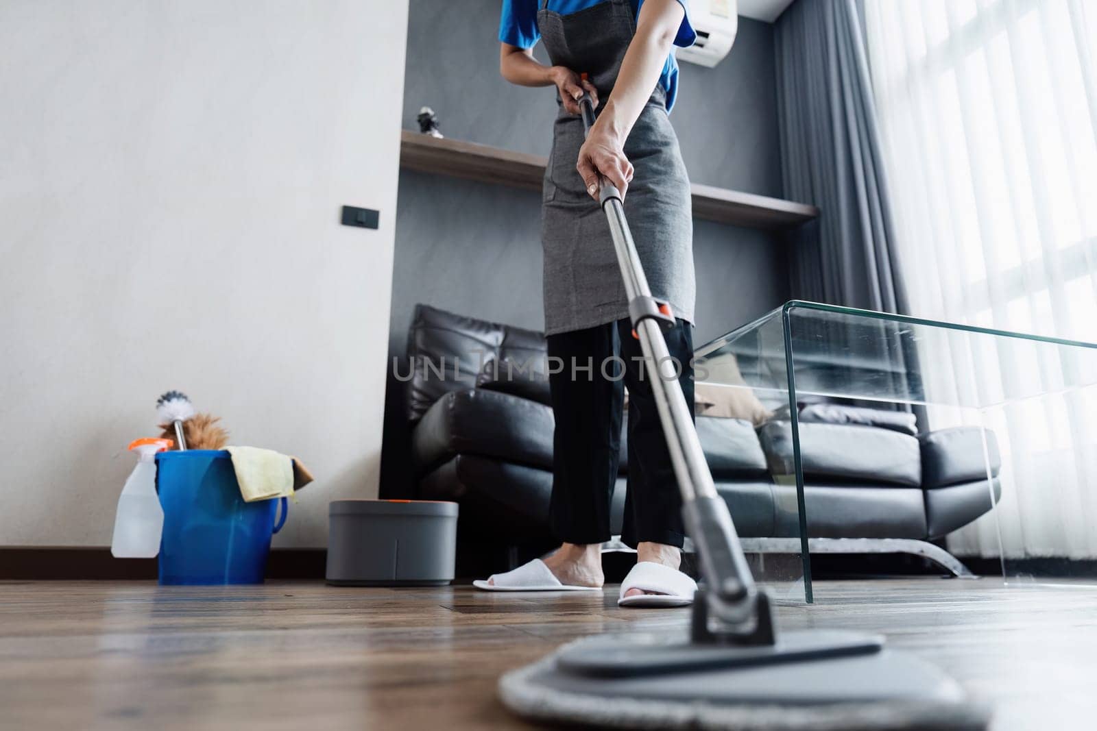 cleaning service housekeeper women swipe floor in living room. House cleaning service concept.