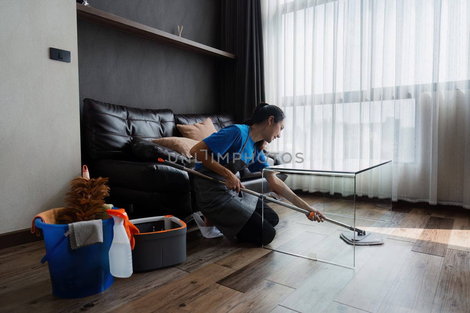 Housekeeping woman wiping the table in the living room House cleaning service concept by itchaznong