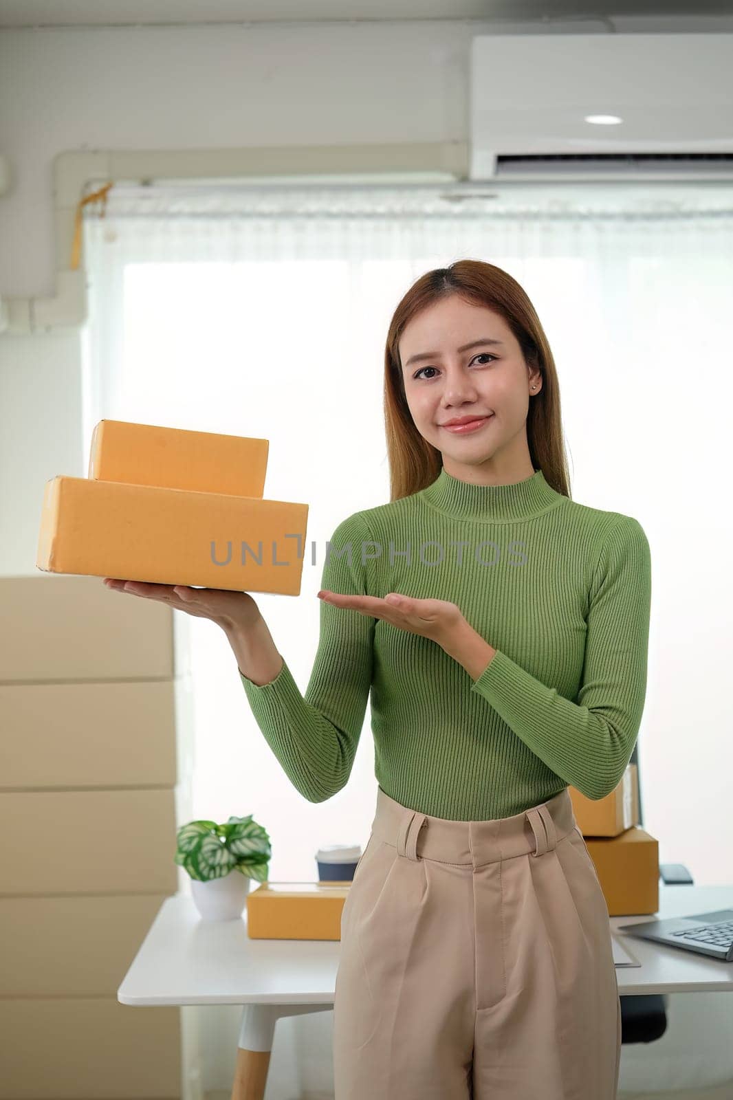 Young business woman asian working online ecommerce shopping at her shop. Young woman sell prepare parcel box of product for deliver to customer. Online selling by nateemee