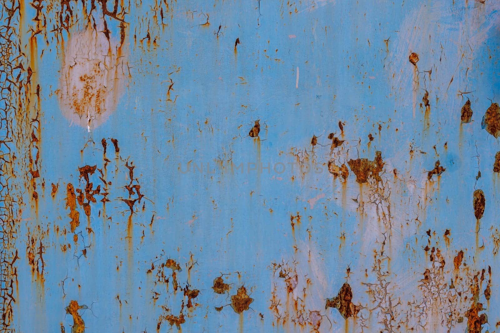 faded blue paint on flat sheet steel surface with stains of rust - full-frame background and texture.