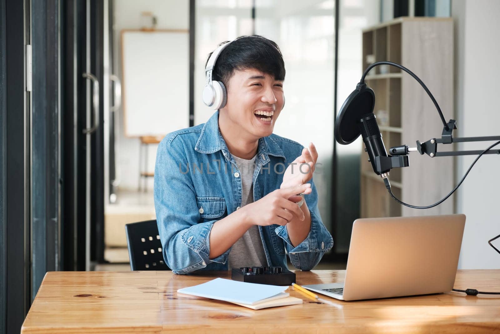 A man wearing headphones is smiling and clapping his hands by ijeab