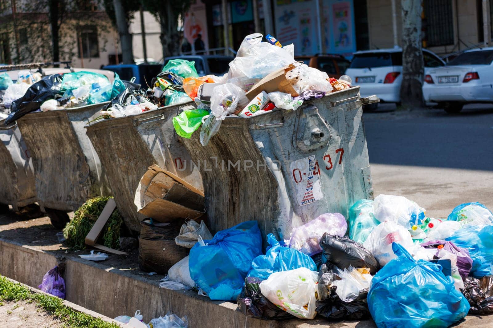 overfilled public trash bins at summer day in Bishkek, Kyrgyzstan - May 26, 2023