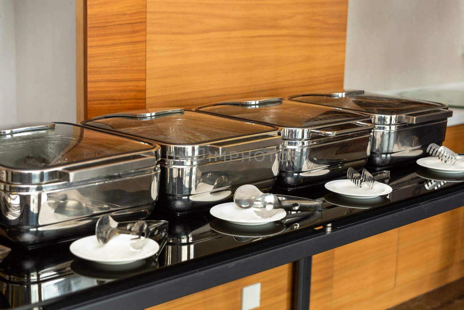 Row of closed chafing dishes at party banquet hall. by BY-_-BY