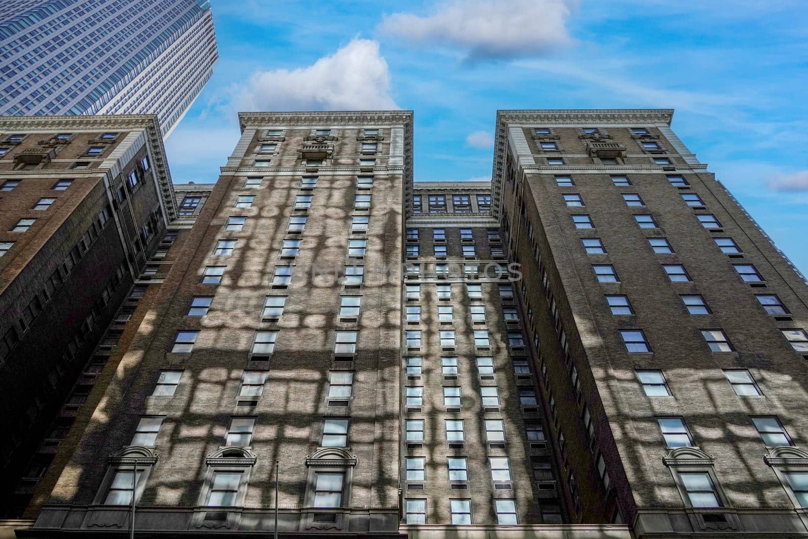 new york manhattan skyscrapers view from the street to the top of the building on sunny clear day by AndreaIzzotti