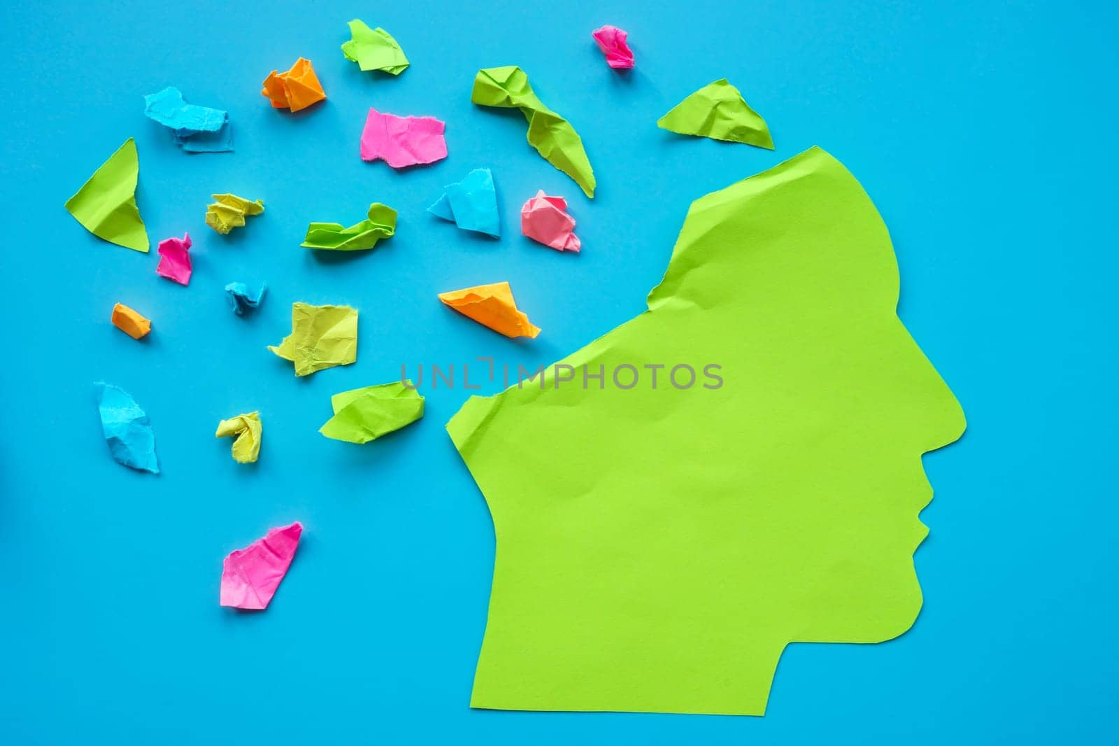 Mindfulness, positive thinking and mental health. Paper head with colored pieces of paper. by designer491