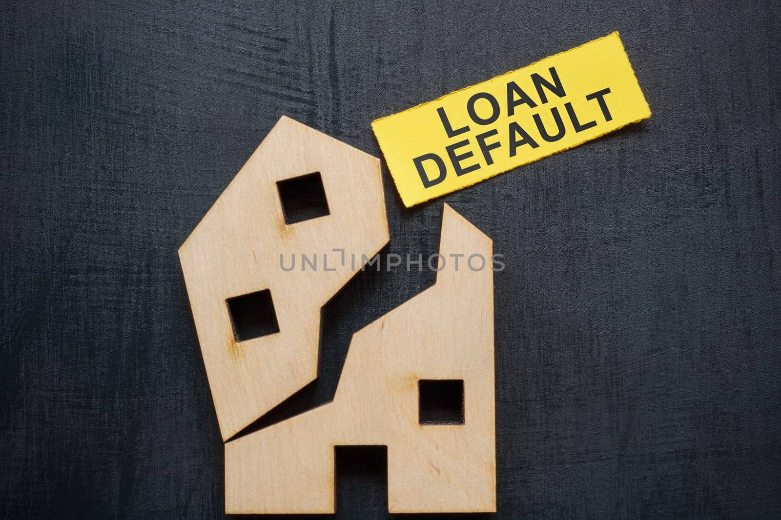 Loan default concept. Broken model of house and a piece of paper.