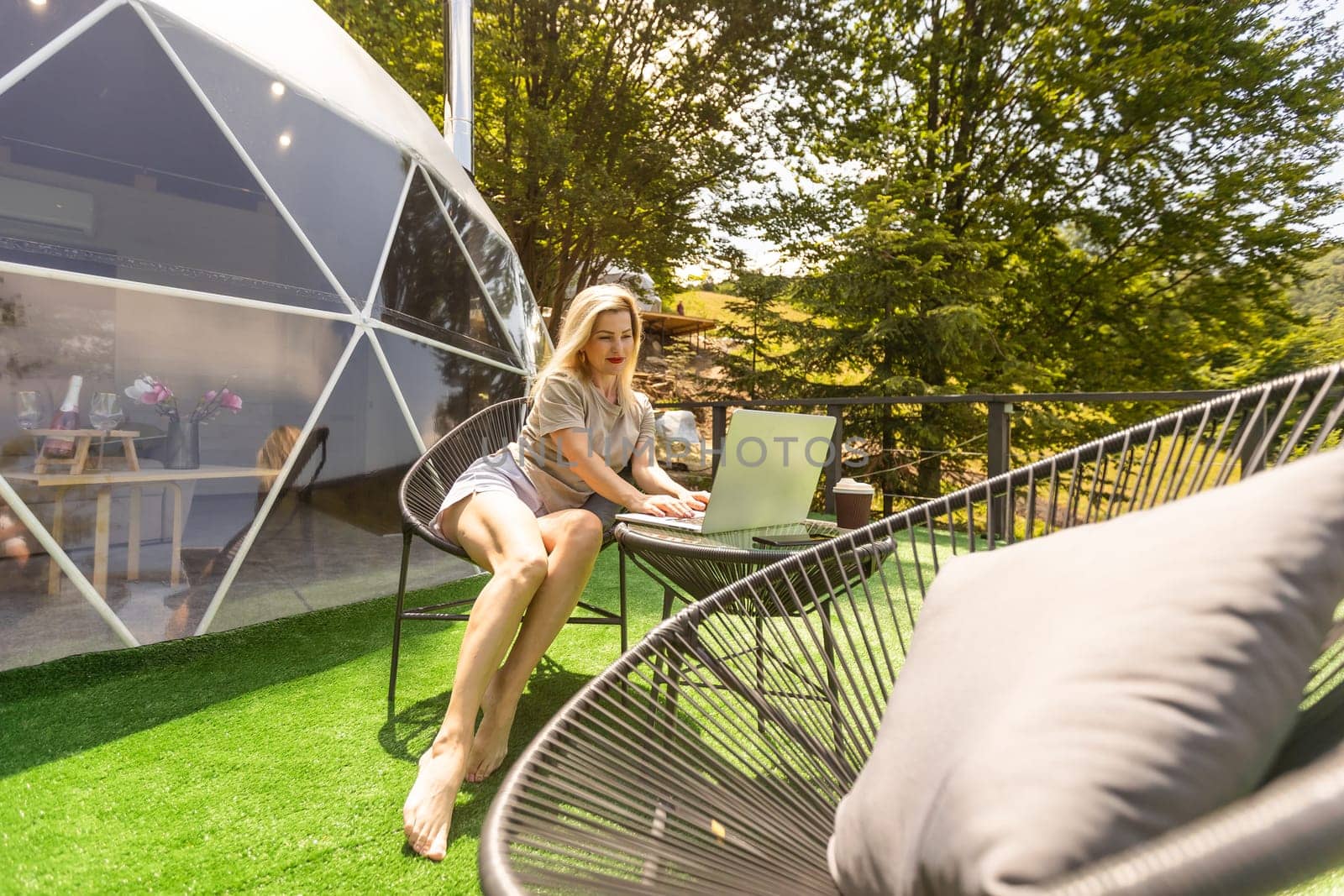woman working on laptop Outdoor Bubble Tent House Dome - Nature travel Concept. by Andelov13