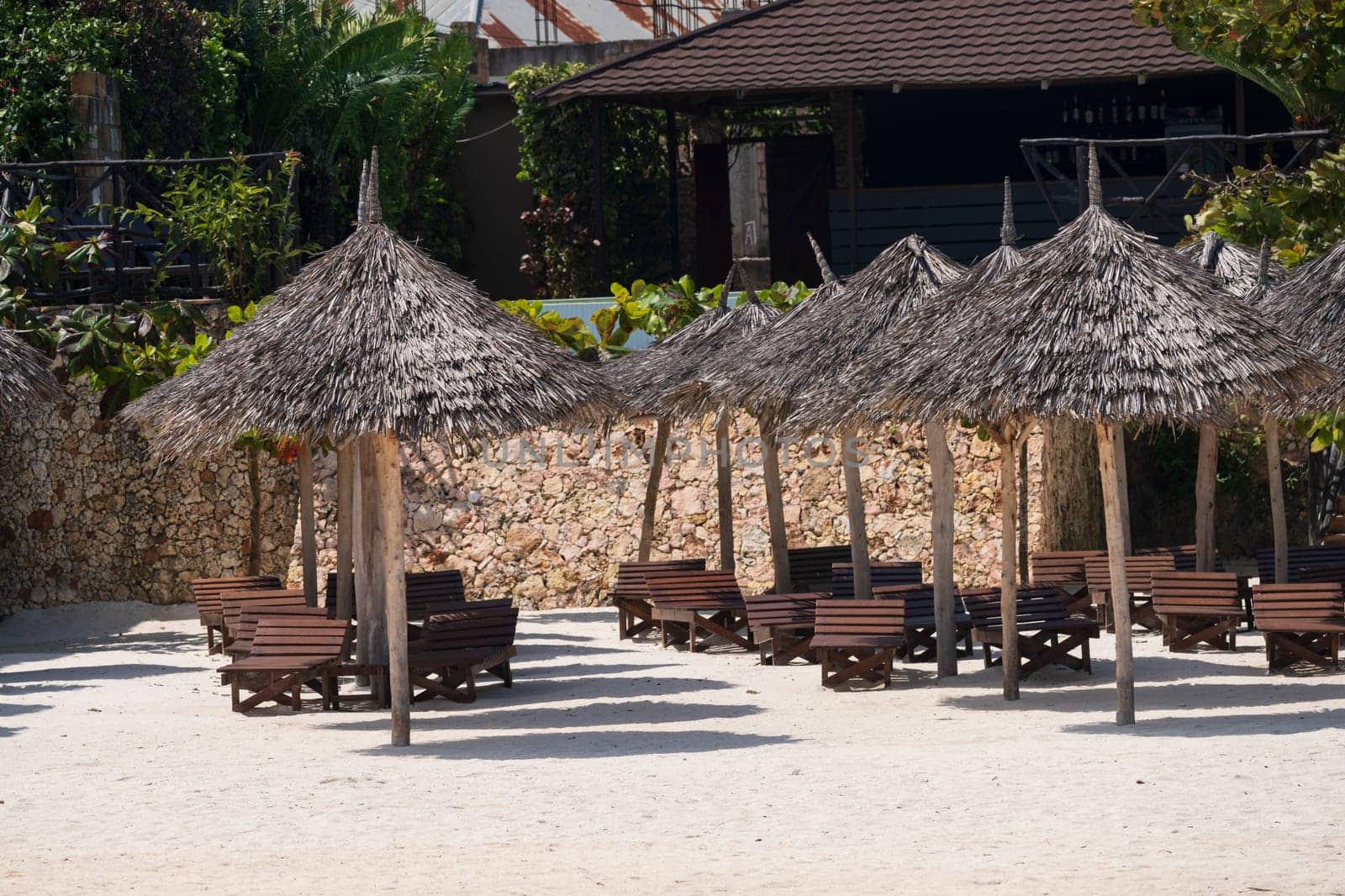 path of wooden umbrellas on sunny day.Luxury beach umbrella at luxurious resort. Summer concept,carefree, rest seaside.