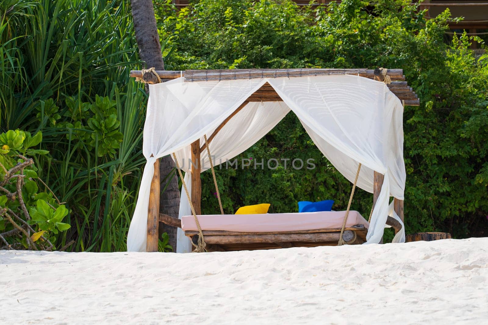 Luxury beach canopies at sunset.White beach tents at luxurious resort. Summer beach concept, carefree, rest seaside, Wonderful garden on the back.