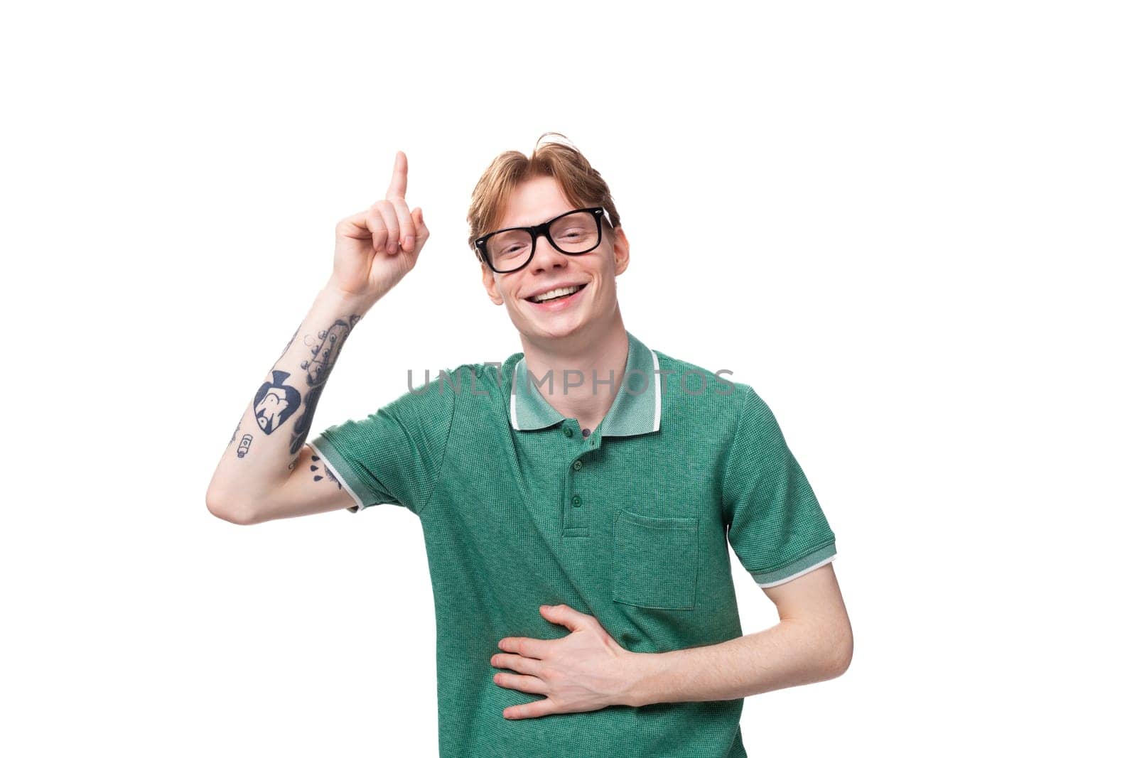 portrait of a young energetic man with red hair pointing fingers up for having an idea.