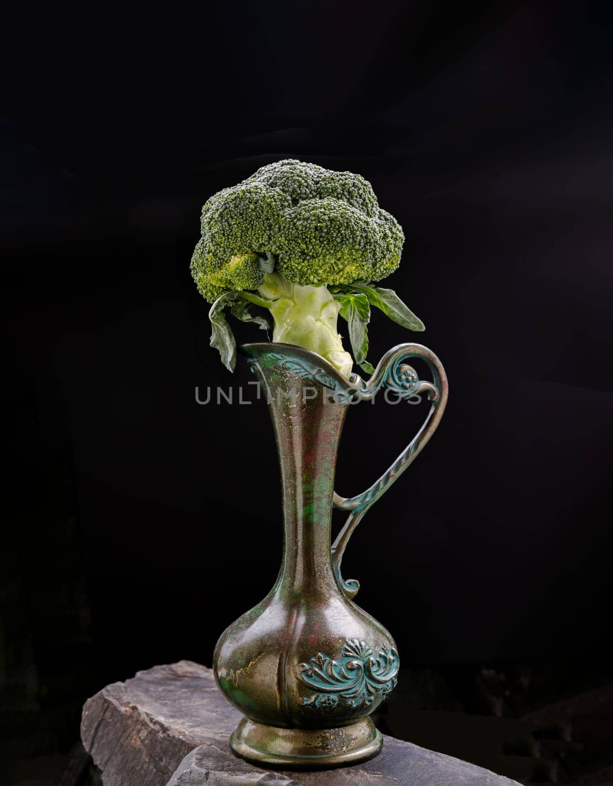 Fresh Green Color Broccoli on Antigue carved iron jug with dark background. Healthy eating concept, Space for text, Selective focus.
