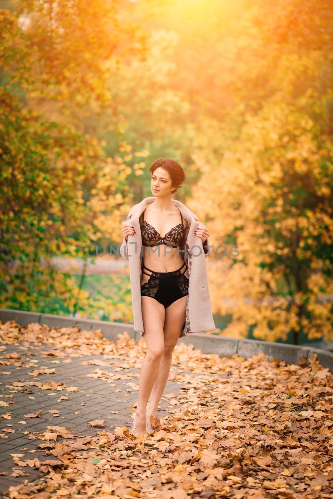 Beautiful young woman in lingerie posing in autumn forest