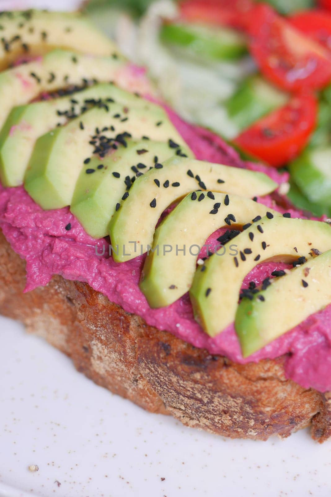 sandwich with avocado and hummus on plate,