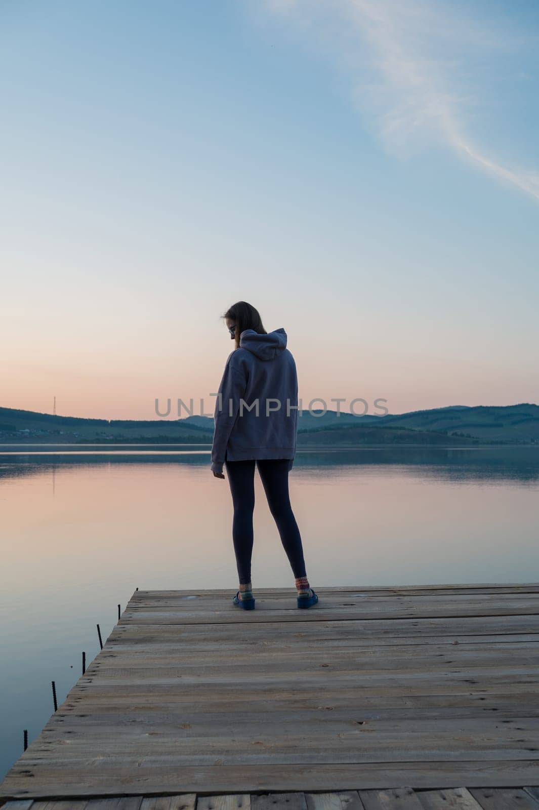 Woman on the pier at lake, closeup portrait, summer sunset