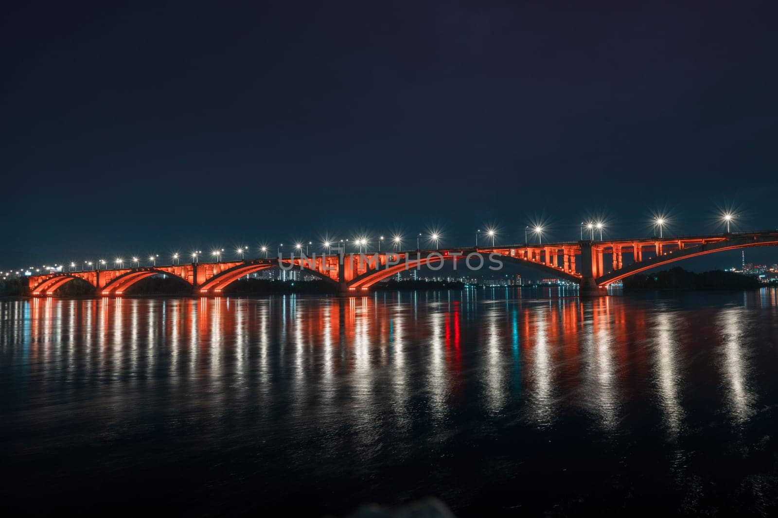 Night view of the famous Communal bridge in Krasnoyarsk through the Yenisei River in Russia, Krasnoyarsk. This bridge is depicted on the 100 rouble bill