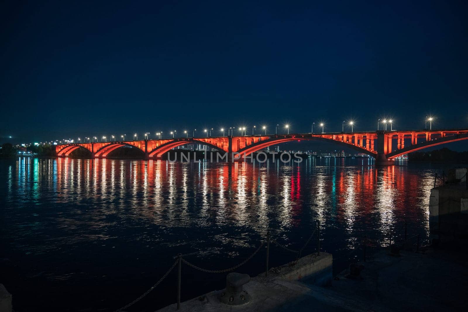 Night view of the famous Communal bridge in Krasnoyarsk through the Yenisei River in Russia, Krasnoyarsk. This bridge is depicted on the 100 rouble bill