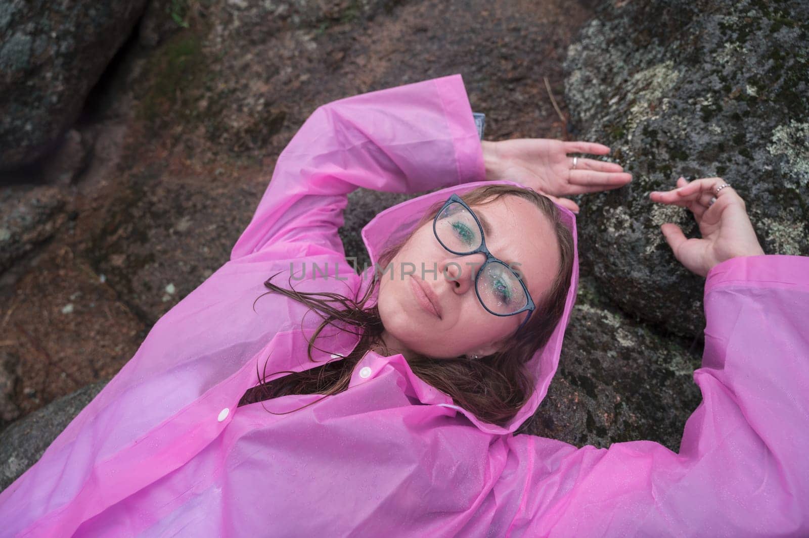 Woman in the raincoat the taiga forest and rocks of the Stolby nature reserve park, Krasnoyarsk, Russia