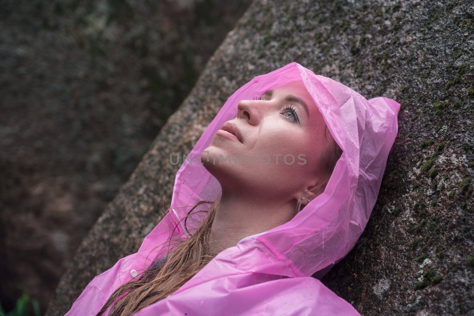 Portrait of woman in the raincoat the taiga forest and rocks of the Stolby nature reserve park, Krasnoyarsk, Russia