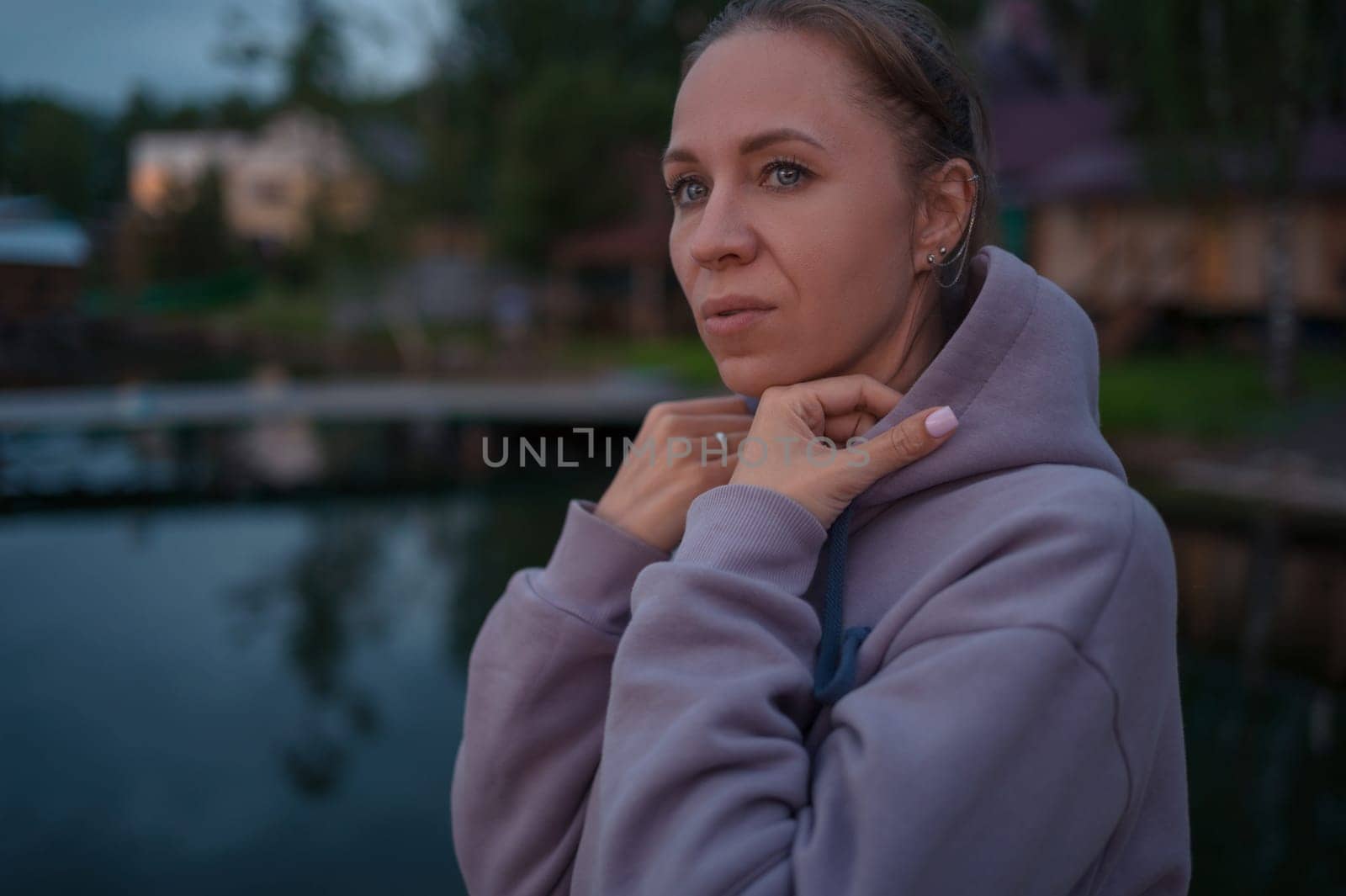 Woman sitting on the pier, closeup portrait, summer sunset