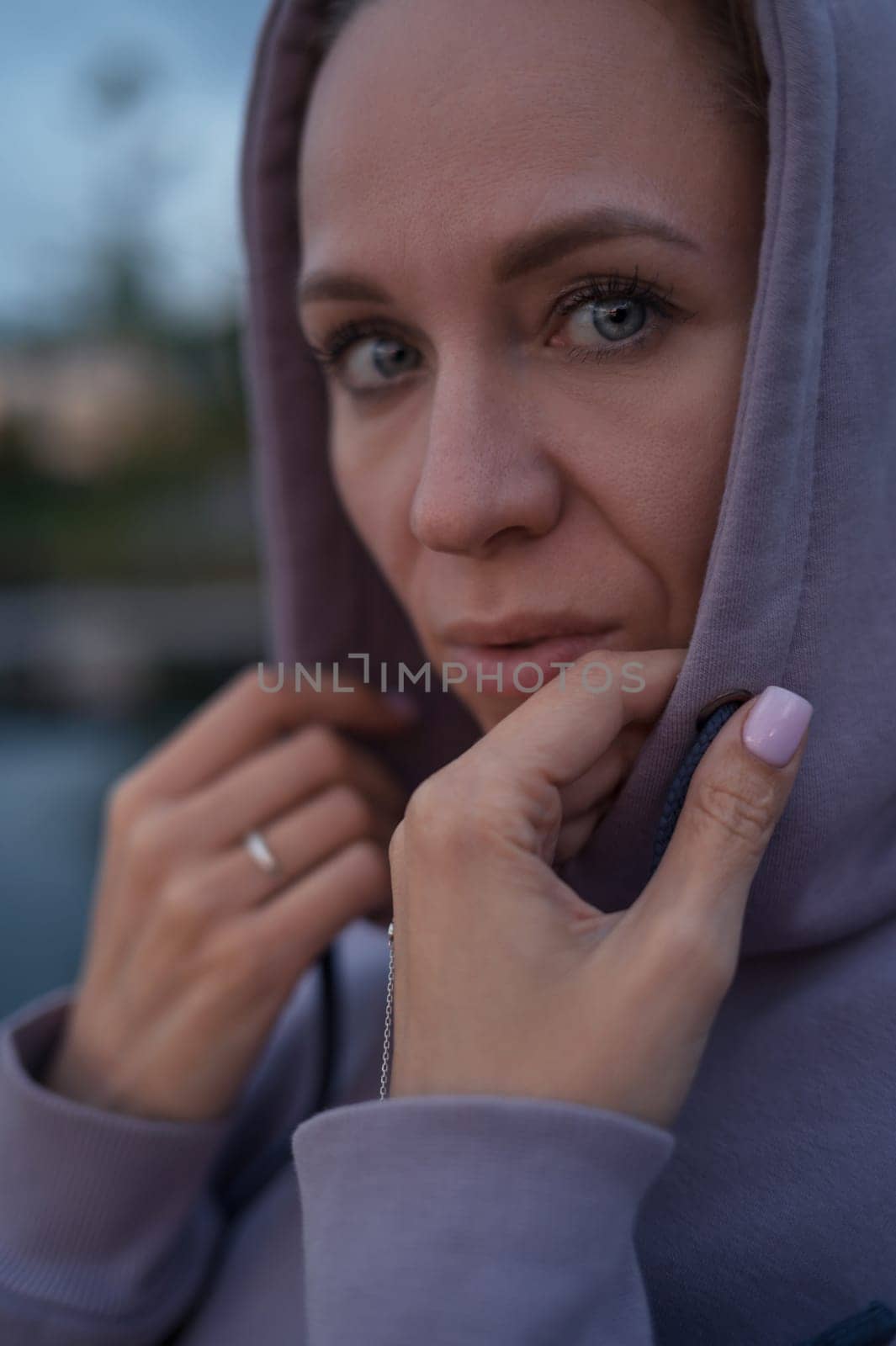 Woman sitting on the pier, closeup portrait, summer sunset