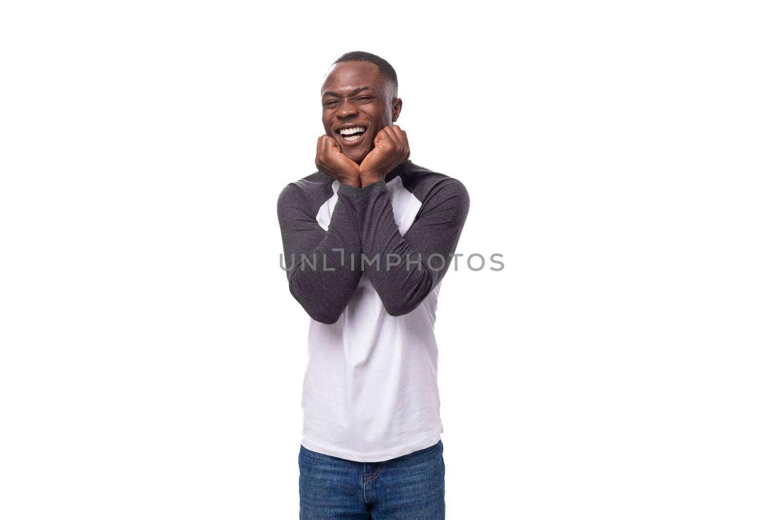 portrait of a young african man with a short haircut wearing a long sleeve sweatshirt on a white background with copy space.