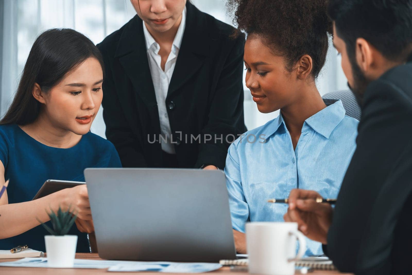 Happy diverse business people work together, discussing in corporate office. Professional and diversity teamwork discuss business plan on desk with laptop. Modern multicultural office worker. Concord