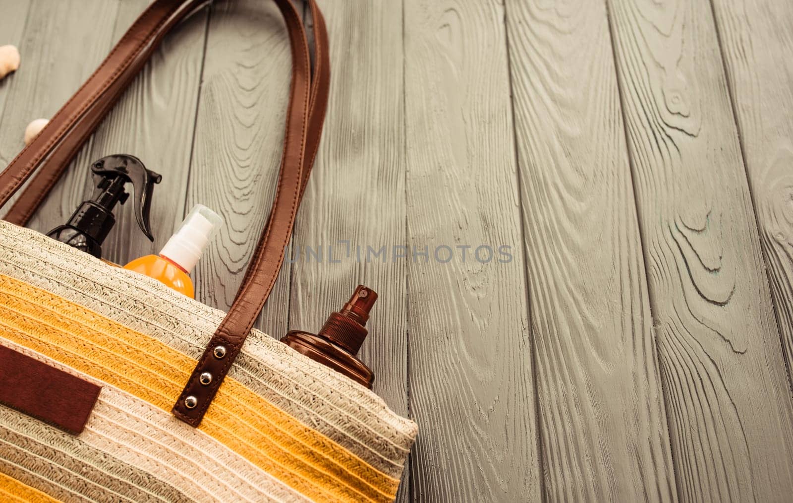 beachwear bag sun protection sunglasses sunscreen spray lotion cream care tan ultra-violet rays. Summer background template mockup free space pattern composition text. Top view above wooden background