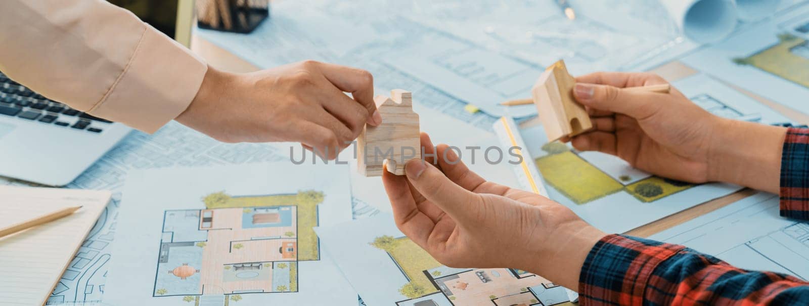 Professional engineer and architect collaborate on eco house project at meeting table with green design blueprint and architectural equipment at modern office. Focus on hand. Close up. Delineation.