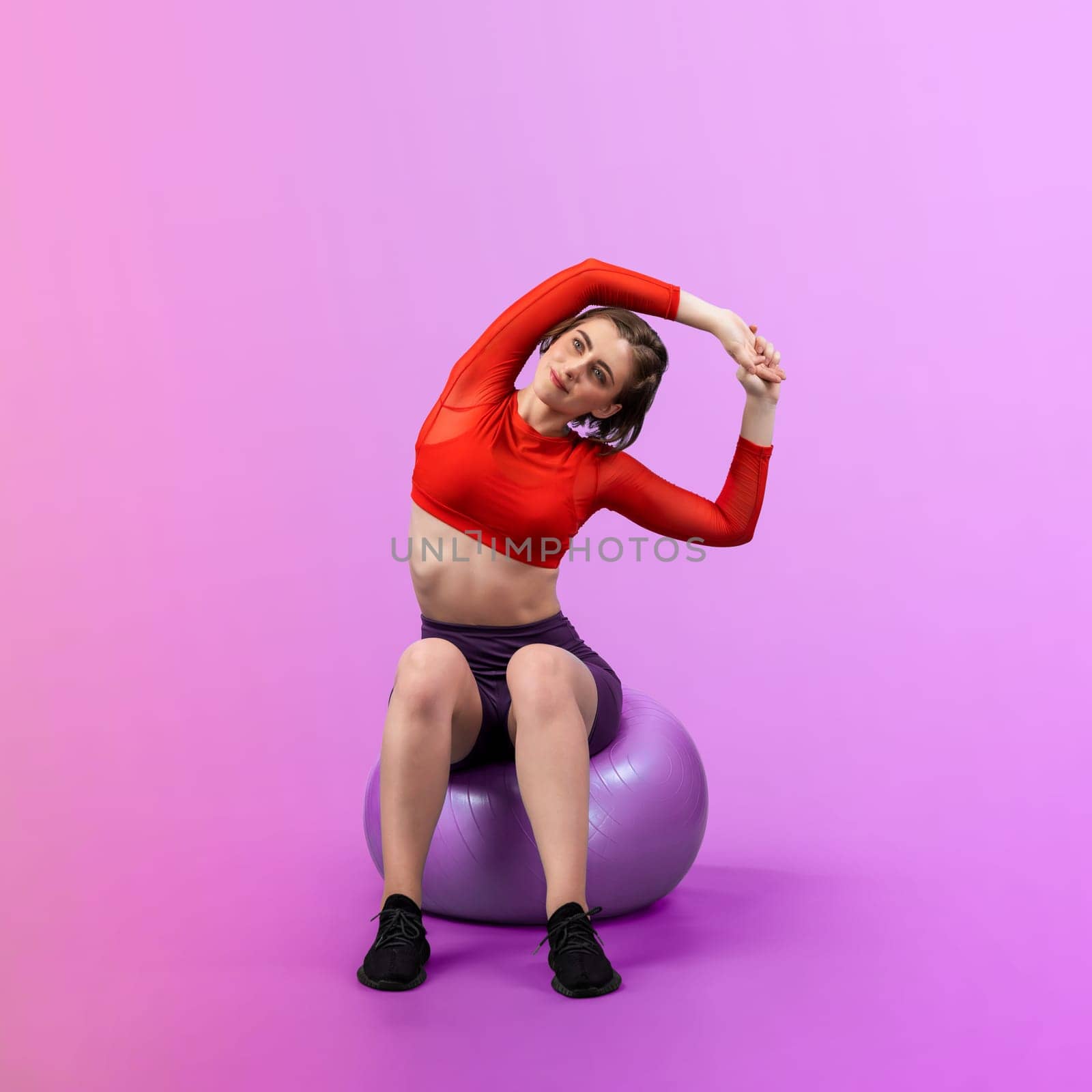 Full body length gaiety shot athletic and sporty young woman with fitness exercising ball in standing posture on isolated background. Healthy active and body care lifestyle.