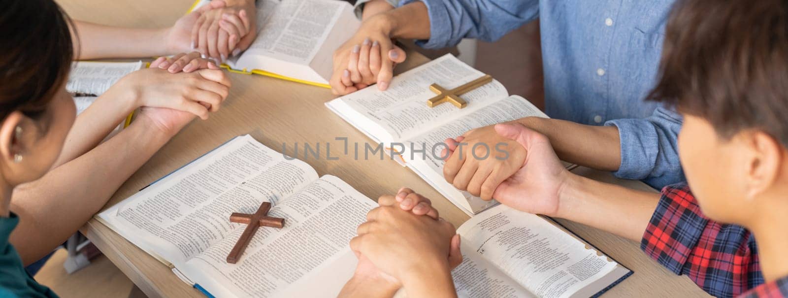 Believer hand praying together on bible book while holding hand. Burgeoning by biancoblue