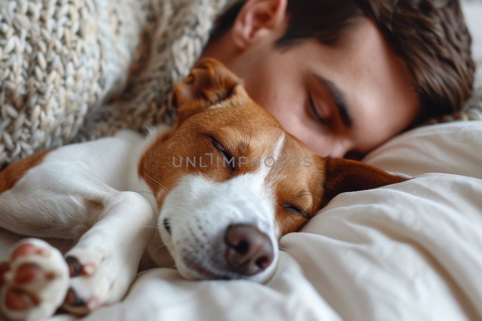 A man is sleeping with his dog on a bed. The dog is laying on the man's chest