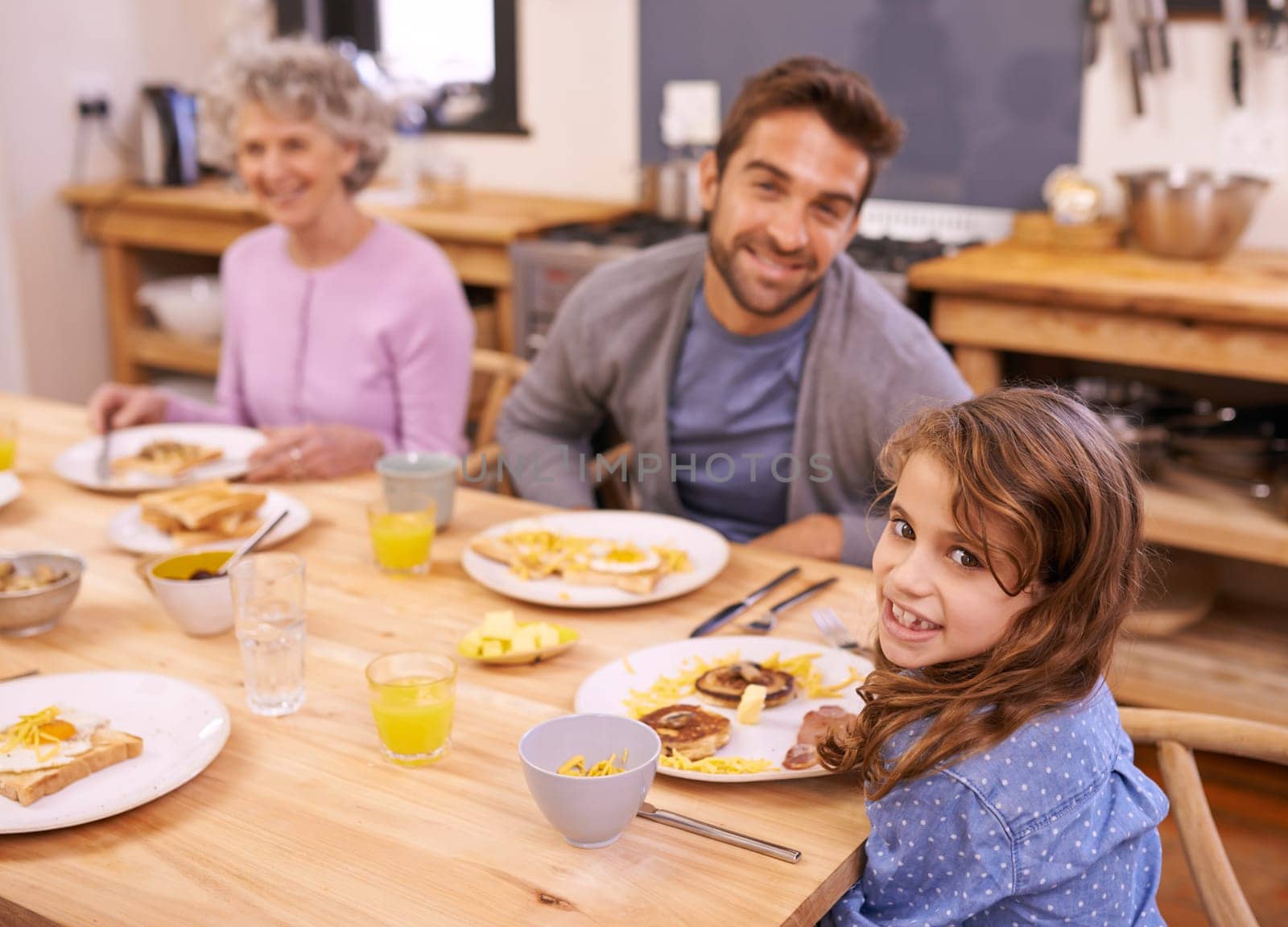 Love, breakfast and family in portrait or kitchen with food, eating or bonding together at table. Meal, pancakes and father or grandmother with child for brunch, nutrition or communication at home.