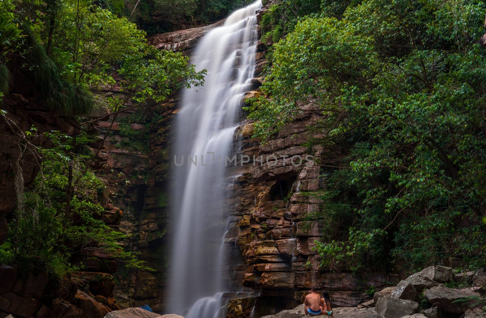 Unidentified Couple Enjoying Silky Waterfall in Lush Canyon by FerradalFCG
