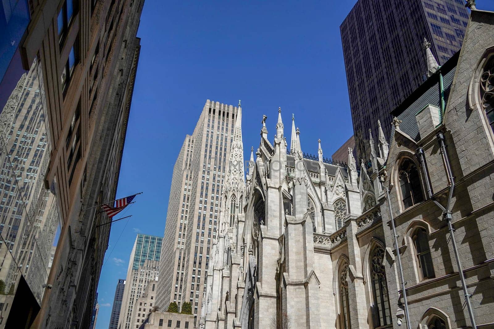 new york manhattan skyscrapers view from the street to the top of the building on sunny clear day by AndreaIzzotti