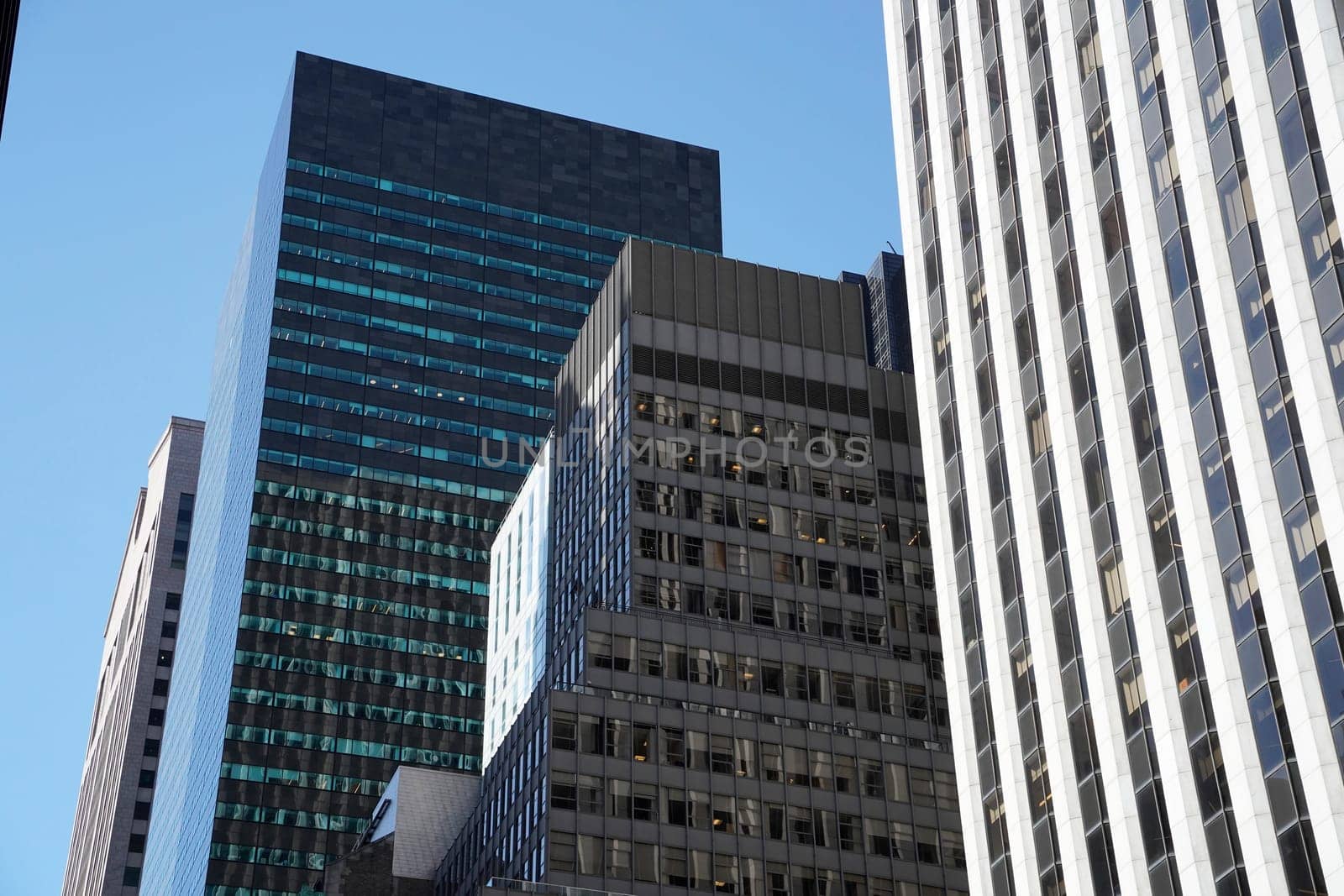 new york manhattan skyscrapers view from the street to the top of the building on sunny clear day by AndreaIzzotti