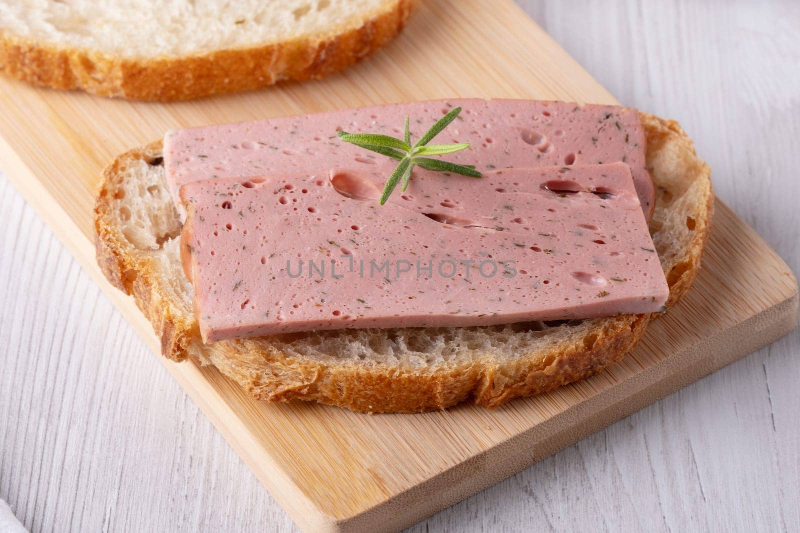 Boiled ham sandwich on a cutting board.