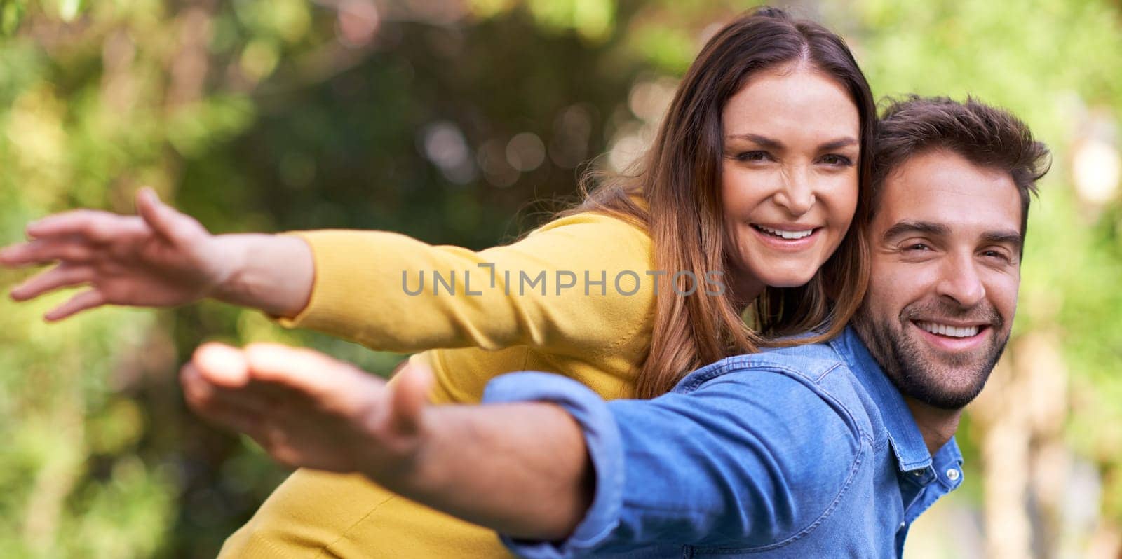 Piggy back, outdoor and portrait with couple, love and smile with happiness and bonding together with romance. Face, relationship and park with man and woman with vacation and sunshine with marriage.