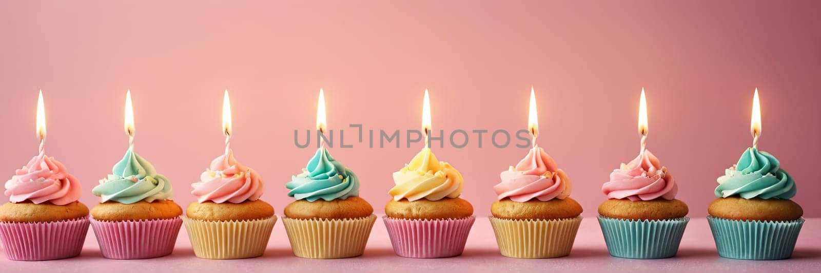 Colorful cupcakes with lit candles are displayed against a pink background, indicating an indoor celebration event marking of joy and celebrating. with free space by Matiunina