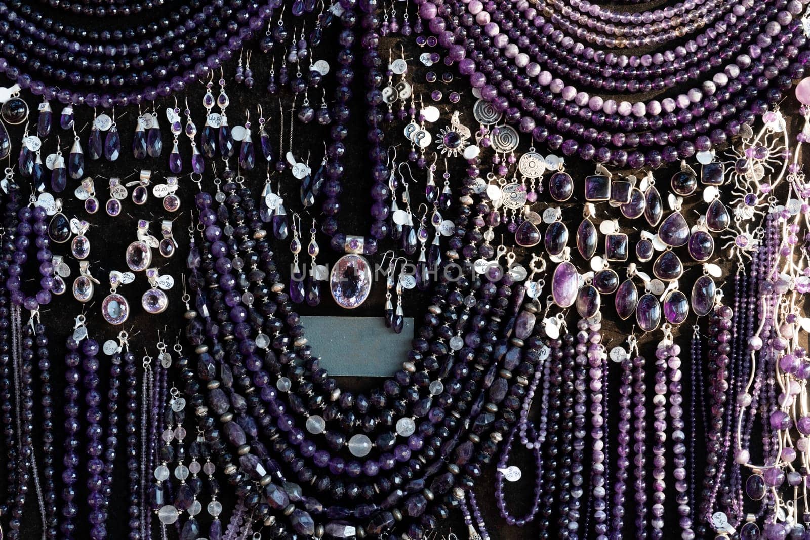 Amethyst necklage earrings jewelry on display stand in a shop market by AndreaIzzotti