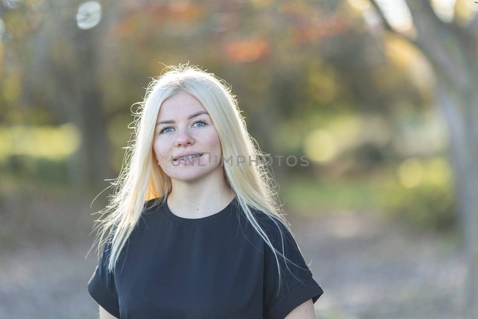 Young Woman with braces in Black Shirt Posing in autumn park by Studia72