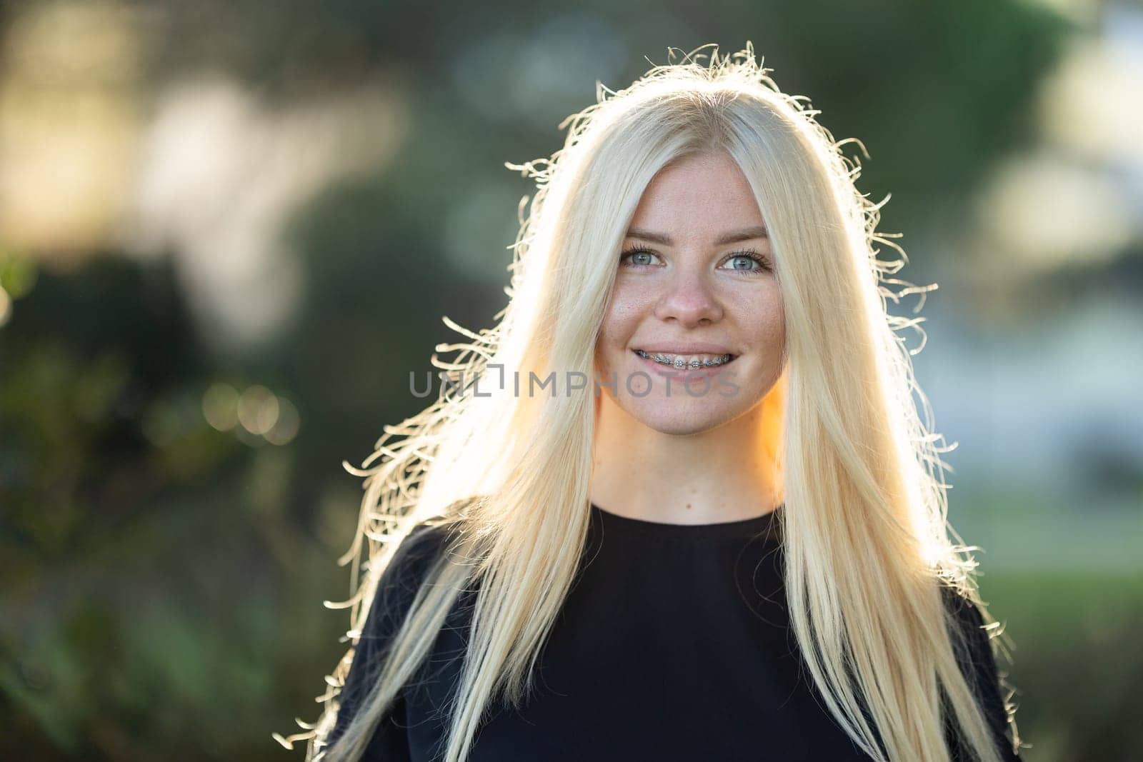 Smiling Woman with braces With Long Blonde Hair posing in the park by Studia72
