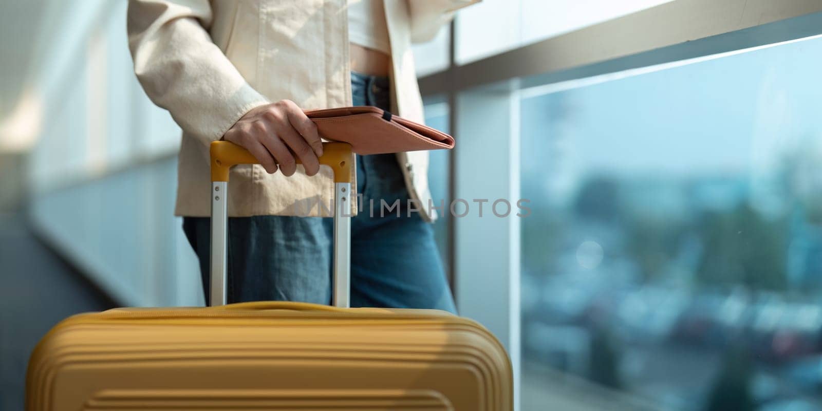 Hand of woman passenger holding passport with the flight in airport terminal by nateemee