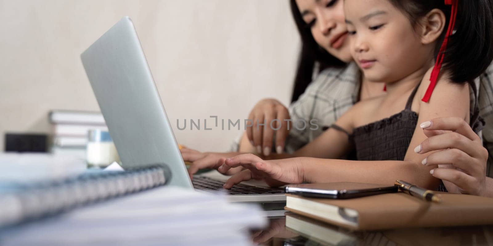Working mom work from home office. businesswoman and cute child using laptop work freelancer workplace in home, Lifestyle family momen.