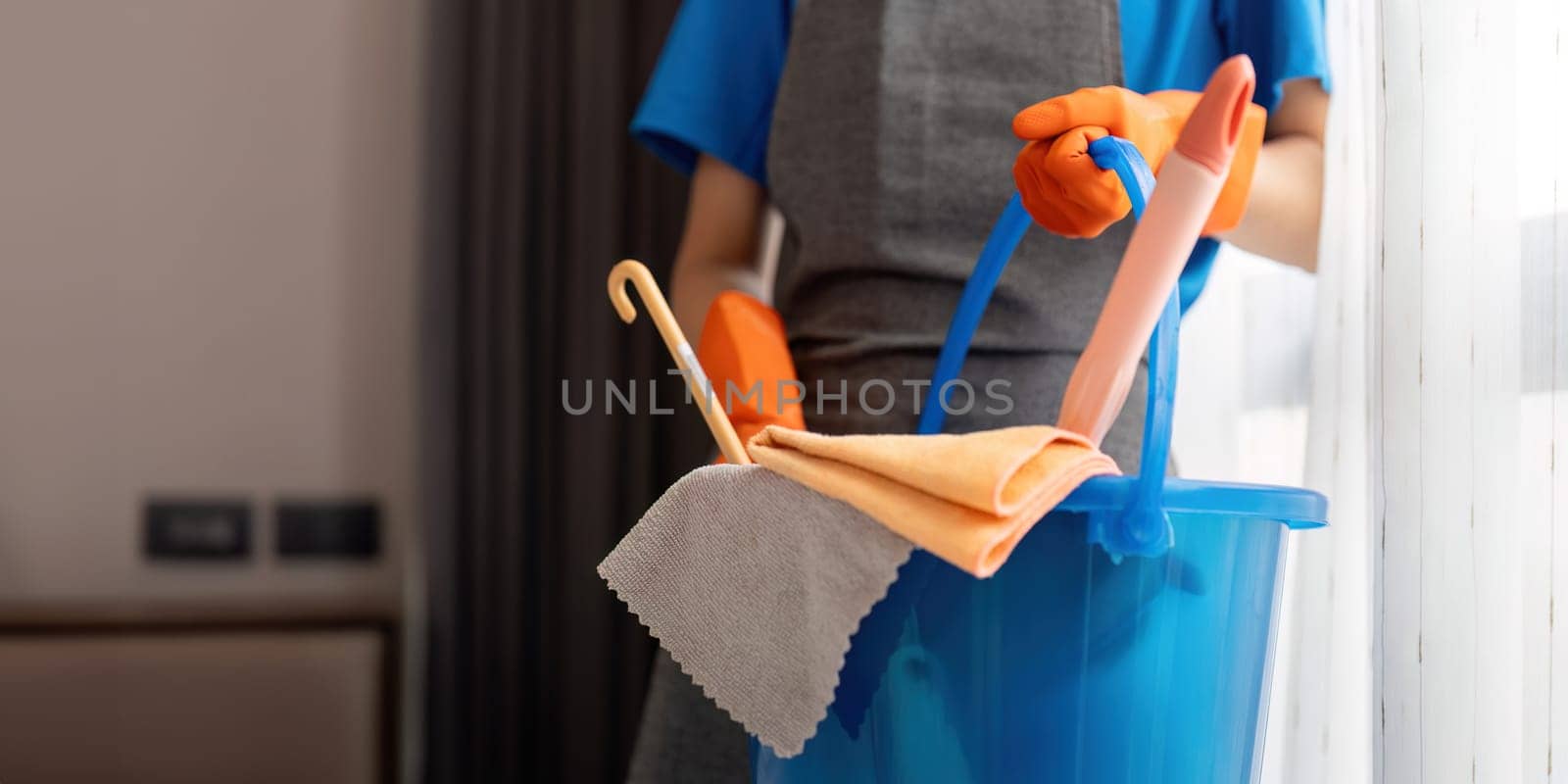 Cleaning product, and basket with woman asian staff cleaning service in bedroom to clean bacteria at apartment. cleaner or maid with container to work in room.