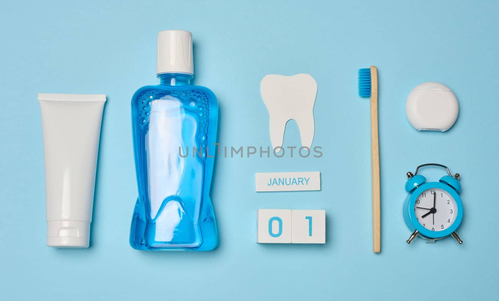 Mouthwash, toothpaste tube, dental floss on a blue background, oral hygiene.  by ndanko