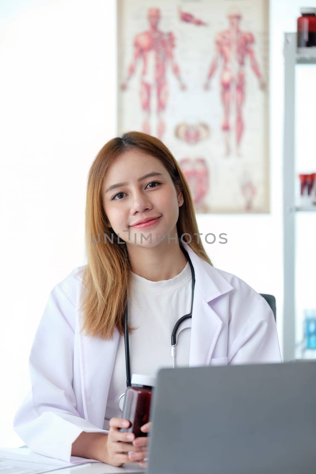 Female doctor working at office desk at in health clinic or hospital.