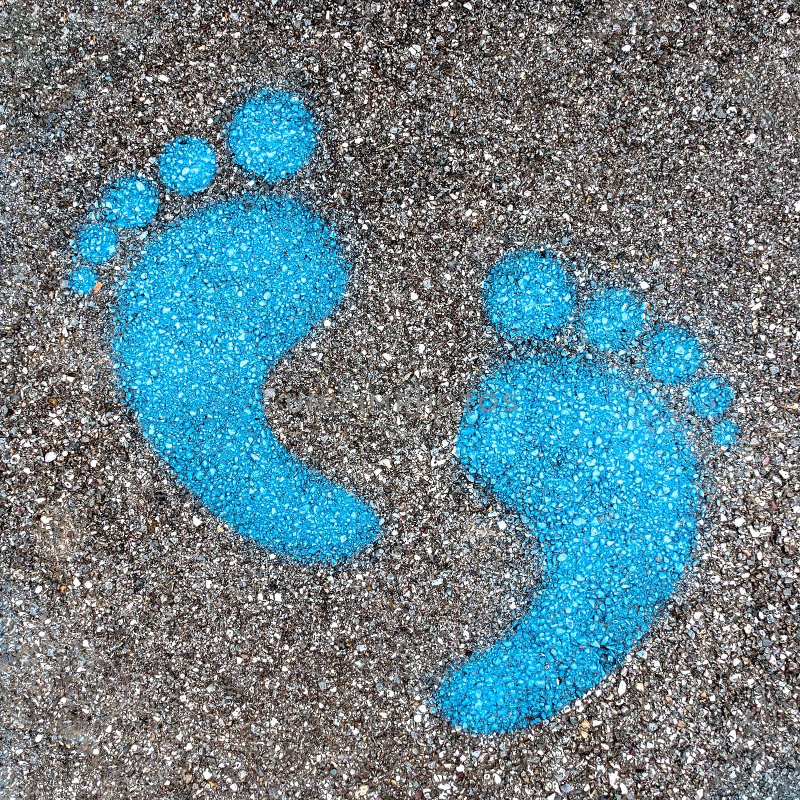 Blue footprint signs on an asphalt  by germanopoli