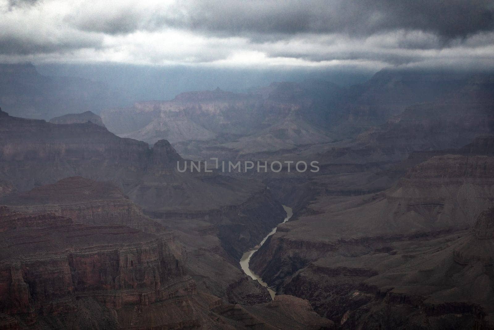 Passing rain storm produces clouds that filter the sunlight at Grand Canyon National Park, Arizona