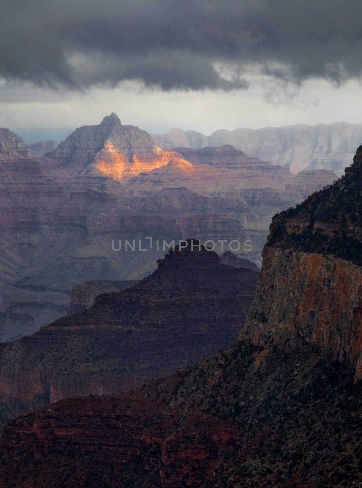 Passing rain storm produces clouds that filter the sunlight at Grand Canyon National Park, Arizona