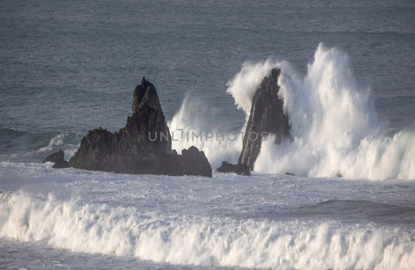 Powerful waves crash upon the beach alog the Pacific Ocean at Big Sur, Californias